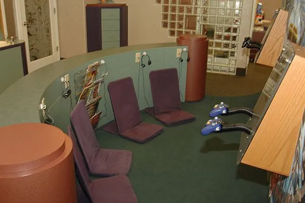 Dedicated arcade gaming zone with custom console seats for patient entertainment